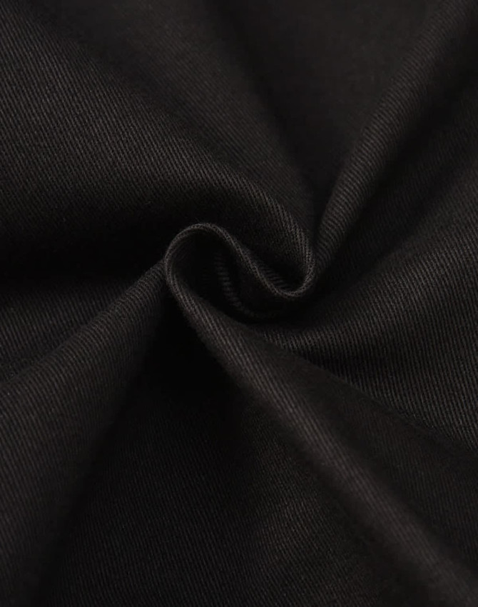 A close-up of black cotton fabric, showcasing a smooth and sturdy texture suitable for work pants.