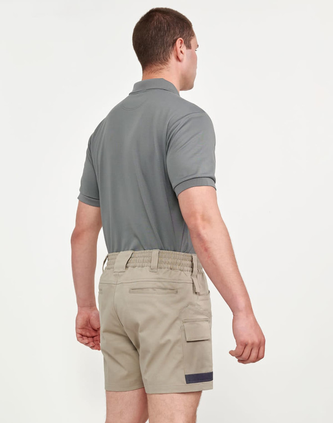 Unisex cotton stretch drill short work shorts in beige, paired with a grey polo shirt, shown from the back.