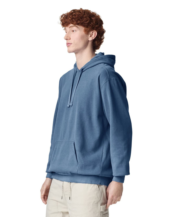 A blue adult hooded sweatshirt with a front pocket and a drawstring hood is displayed on a male model.