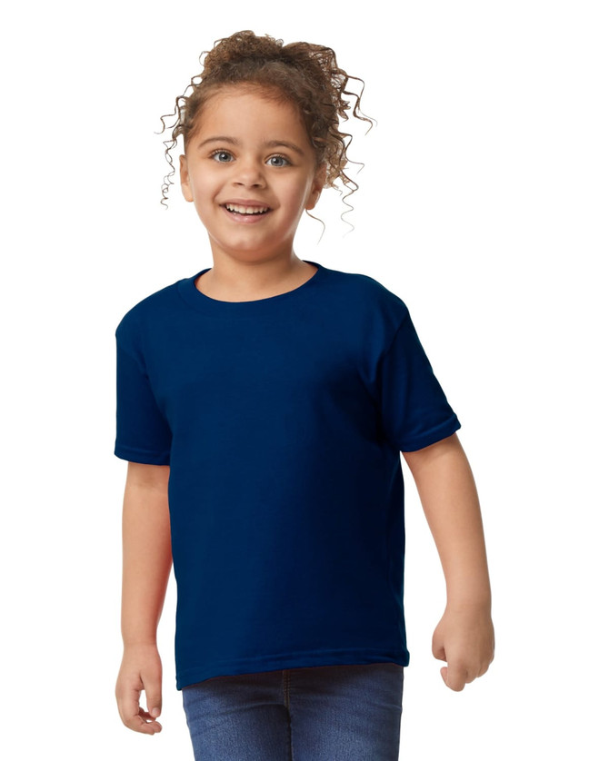A toddler wearing a navy blue Gildan Heavy Cotton T-Shirt, smiling and standing with hands on hips.