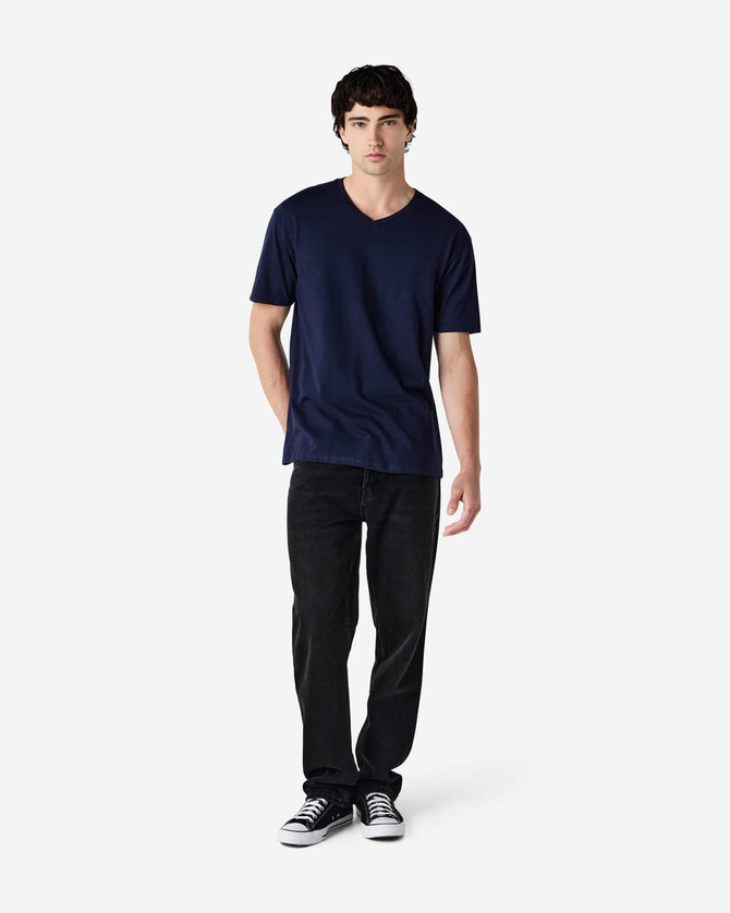 A navy blue Gildan Softstyle adult V-neck T-shirt displayed on a model, paired with black jeans and sneakers.