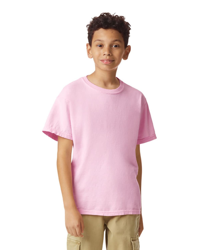 A pink youth short sleeve t-shirt displayed on a person, featuring a simple design and a logo.