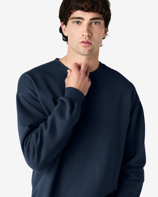 A navy Gildan Softstyle adult sweatshirt featuring a crew neck and long sleeves, with a logo on the sleeve.