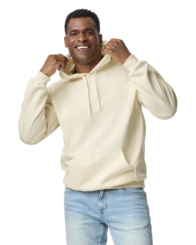 A hooded sweatshirt in cream, featuring a front pocket and a drawstring hood, modelled by a smiling man.
