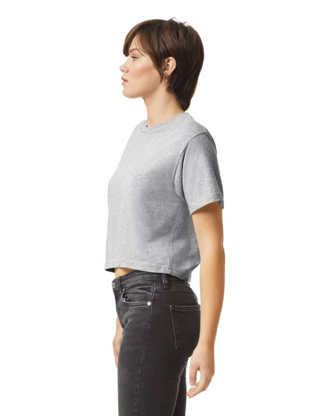 A grey women's fine jersey boxy T-shirt, featuring short sleeves and a cropped design, displayed on a model in profile.