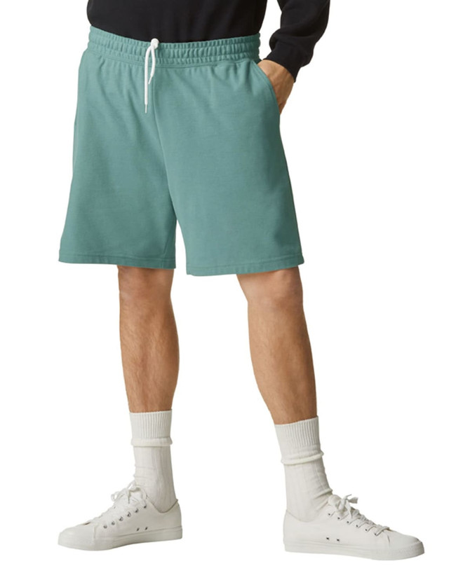 A pair of teal unisex gym shorts with an elastic waistband and side pockets, worn with white sneakers and socks.