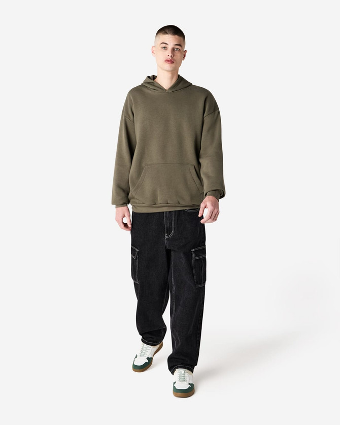 A model wearing an olive green unisex hooded sweatshirt, paired with black cargo pants and sneakers.