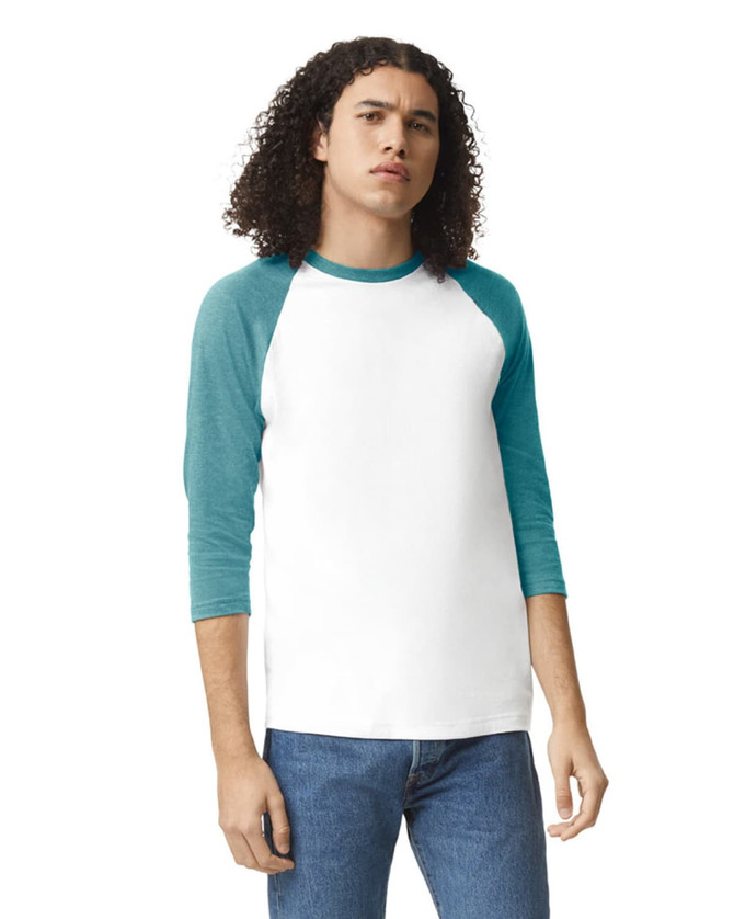 A unisex raglan t-shirt featuring a white body with teal sleeves. The model has curly hair and is wearing jeans.