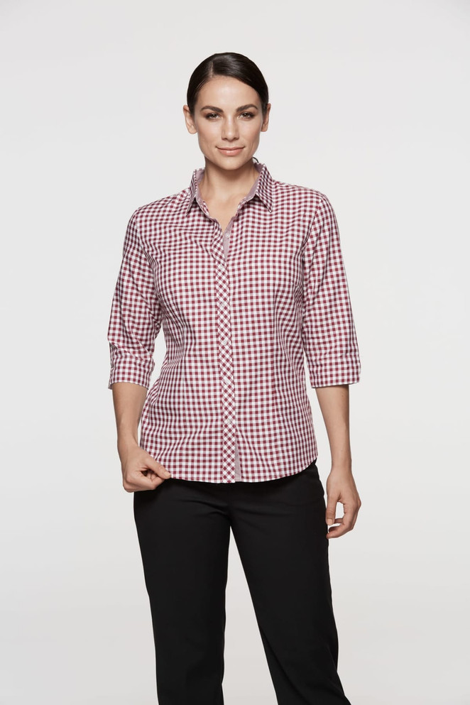 A model wearing a red and white checked button-up shirt with 3/4 sleeves, paired with black pants.