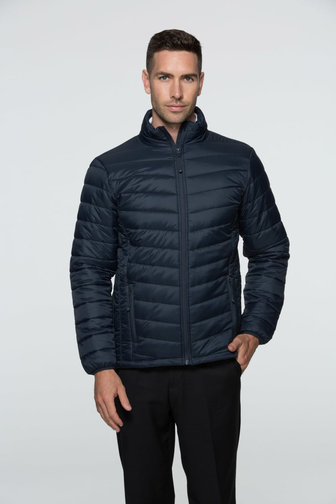 A man wearing a navy blue puffer jacket with a zip front and a stand-up collar, featuring a branding logo.