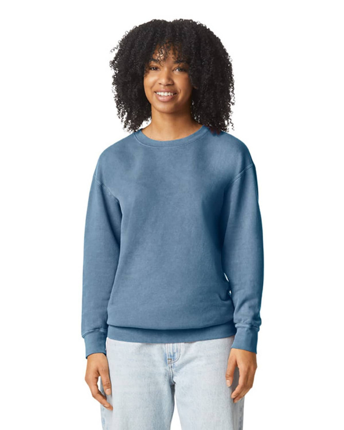 A woman models a blue Comfort Colors Lightweight Crewneck Sweatshirt, featuring long sleeves and a relaxed fit.