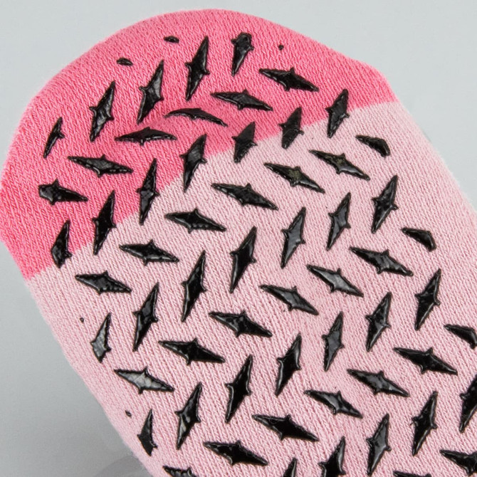 A pair of pink Nero ankle grip socks with black rubber grips on the underside.