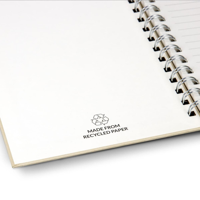 A recycled paper spiral notebook with a white cover and a silver spiral binding, featuring a recycling symbol.