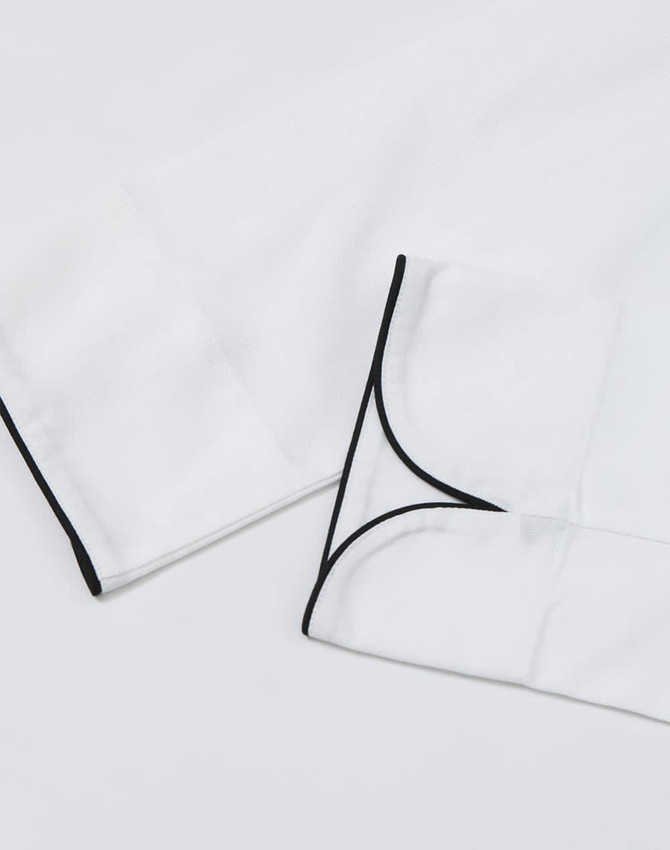 A white unisex executive chef jacket with black piping details on the cuffs. It features a clean, professional design.