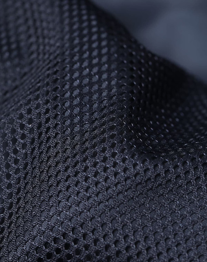 A close-up of a textured black fabric featuring a mesh pattern, ideal for breathable insulation.