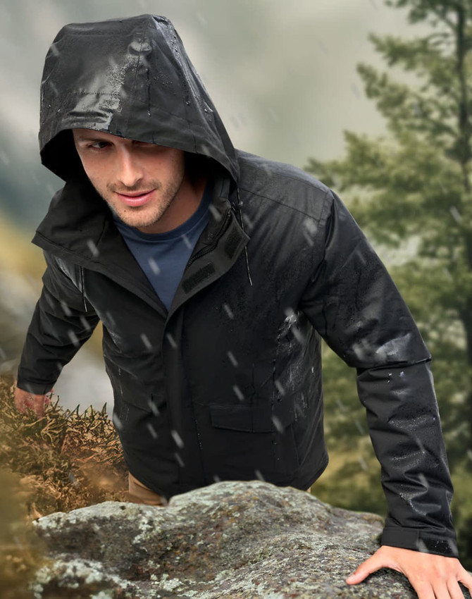 A unisex quilted waterproof jacket in black, featuring a hood, worn by a person outdoors.