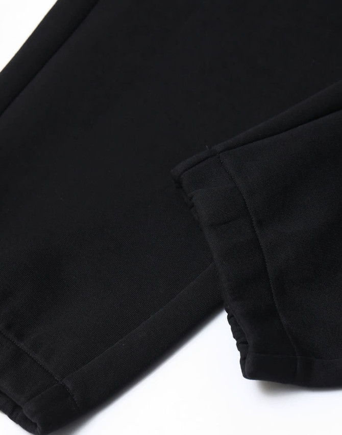 Black unisex sweatpants featuring a soft fabric with a cuffed hem and subtle branding detail.