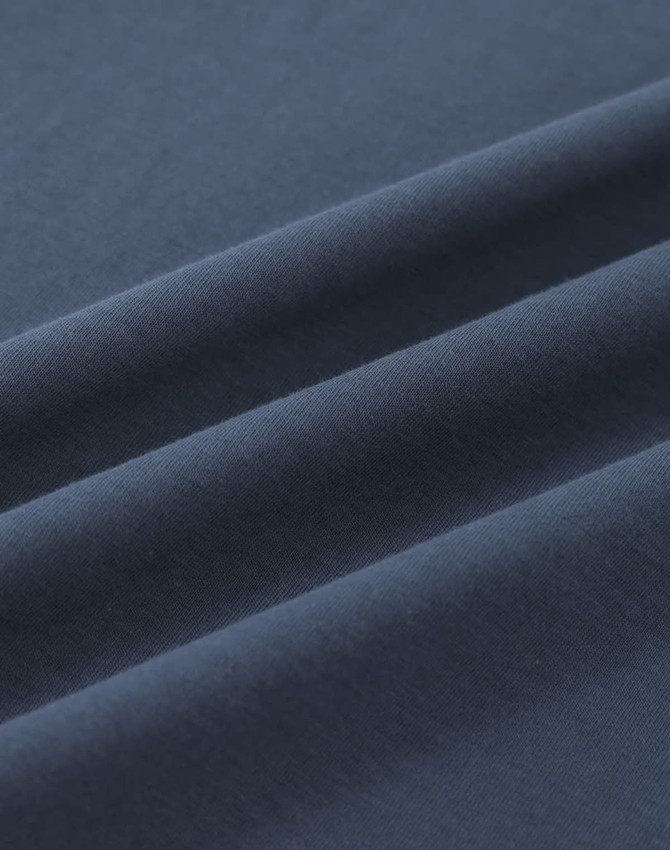 A close-up of dark navy blue cotton fabric, showcasing its smooth texture and folds.