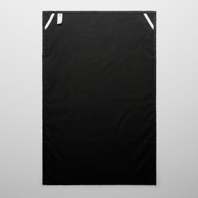 A black tea towel featuring white accents and a small tag. Suitable for home and kitchen use.