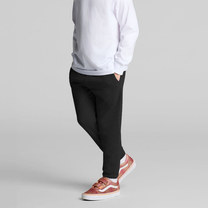 Kids Supply Track Pants in black, featuring side pockets and a relaxed fit, paired with stylish shoes.