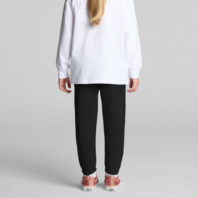 Black track pants for kids, featuring a tapered fit and cuffed ankles, paired with a white long-sleeve top.