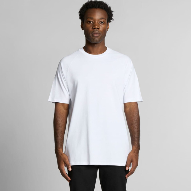 A white Staple Raglan Tee featuring short sleeves and a relaxed fit, displayed by a model.