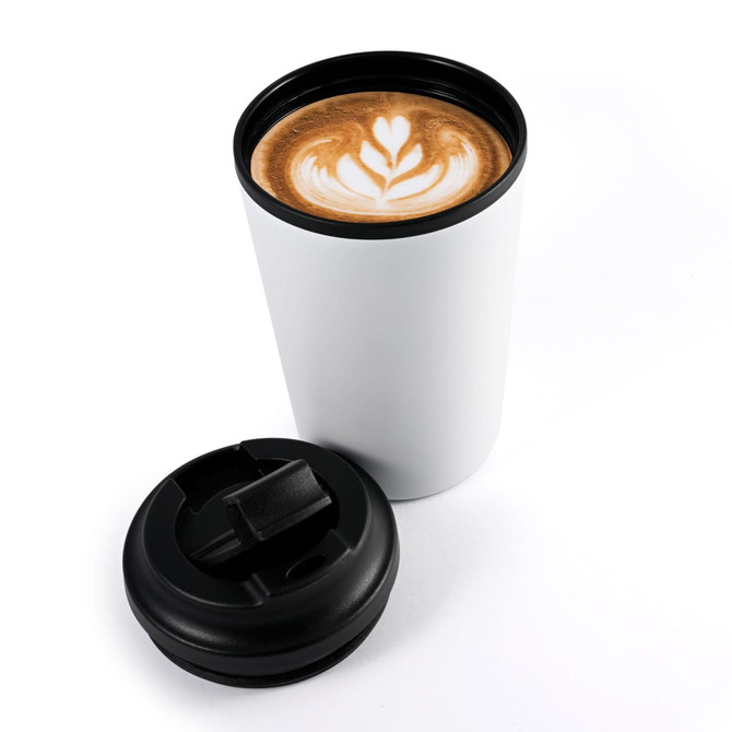 A white reusable coffee cup with a black lid, featuring a latte with a heart-shaped design.