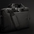 A black Swiss Peak 38cm laptop bag with dual handles and a detachable shoulder strap. Features a solid design and logo.