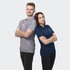 A grey men's polo and a navy women's polo, each with a logo. Both models are standing back-to-back with arms crossed.