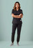 A model wearing black women's jogger scrub pants paired with a matching top, set against a pastel background.