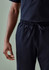 A unisex pair of navy scrub pants with an elastic waistband and adjustable drawstring, featuring a hand on the side.