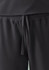 A pair of black jogger scrub pants featuring an elastic waistband and drawstring tie. Logo present.