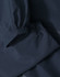 A waterproof jacket in navy blue with elastic cuffs and a sleek design, featuring a logo.