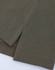 A close-up of olive green fabric with a textured surface, featuring the hem and sleeve of a polo shirt.