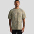A man wearing a heavy faded camo T-shirt in earthy tones, featuring a camouflage pattern and a relaxed fit.