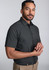 A classic fit short sleeve shirt in dark grey, featuring a button-up design. The model stands with a neutral expression.