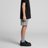 Youth stadium shorts in grey, featuring a logo, paired with a black t-shirt and black sneakers.