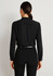 A black long sleeve blouse with a simple design and buttoned cuffs, viewed from the back.