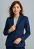 A woman in a navy longline jacket with a fitted design, featuring a single button closure and minimalistic style.