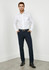 A pair of slim fit men's pants in navy, styled with a white shirt and a belt. There is branding visible.