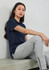A women's short sleeve polo shirt in navy blue, paired with grey pants, displayed against a plain background.