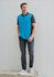 A men's short sleeve polo in blue and grey, featuring a logo, paired with dark jeans and sneakers.