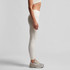Active leggings in a light cream colour, featuring a high waist and a fitted design, paired with casual footwear.