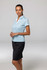 A woman wearing a light blue polo shirt paired with a black skirt, featuring a logo on the shirt.