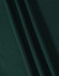 A close-up image of dark green fabric with soft texture, showcasing folds and draping.