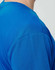 A close-up of a men's short-sleeve t-shirt in a vibrant blue colour with a textured fabric. Features a logo.