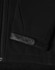 A black softshell jacket featuring a zippered front and a textured patch on the sleeve. It has a logo.