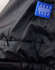 A black heavy quilted jacket featuring a zippered pocket and a label with branding.