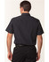 A short sleeve men's button-up shirt in black featuring a pinstripe pattern, with a collar and a logo.