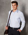 A light blue long-sleeve button-up shirt with a chest pocket, worn by a man holding a brown bag.